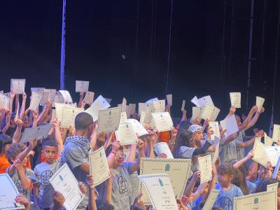 The graduates holding their certificates