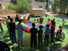 أطفال ذوي اعاقة ذهنية وهم يلعبون ألعابا مختلفة في ساحة الألعاب