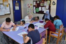 أطفال ذوي اعاقة ذهنية يتعملون مهارات مختلفة في الصف