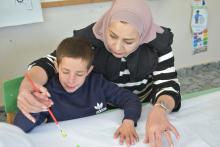 أطفال ذوي اعاقة ذهنية يتعملون مهارات مختلفة في الصف