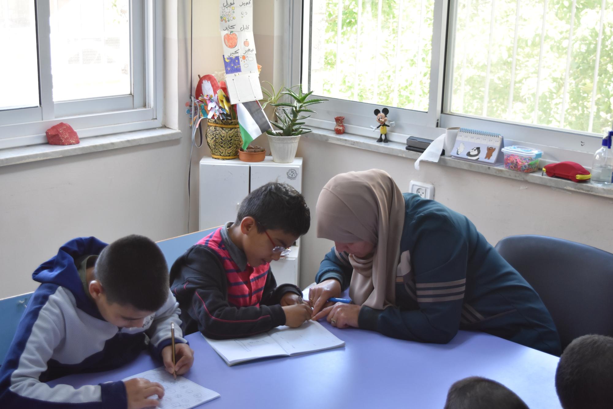 أطفال ذوي اعاقة ذهنية يتعملون مهارات مختلفة في الصف